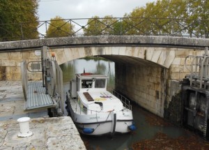 Ros concentrating while driving the boat into a lock